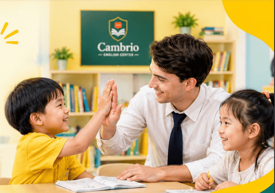 A teacher and two young students smiling and high-fiving in a Cambrio classroom